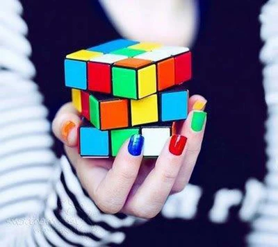 Mão colorida segurando um cubo Rubik