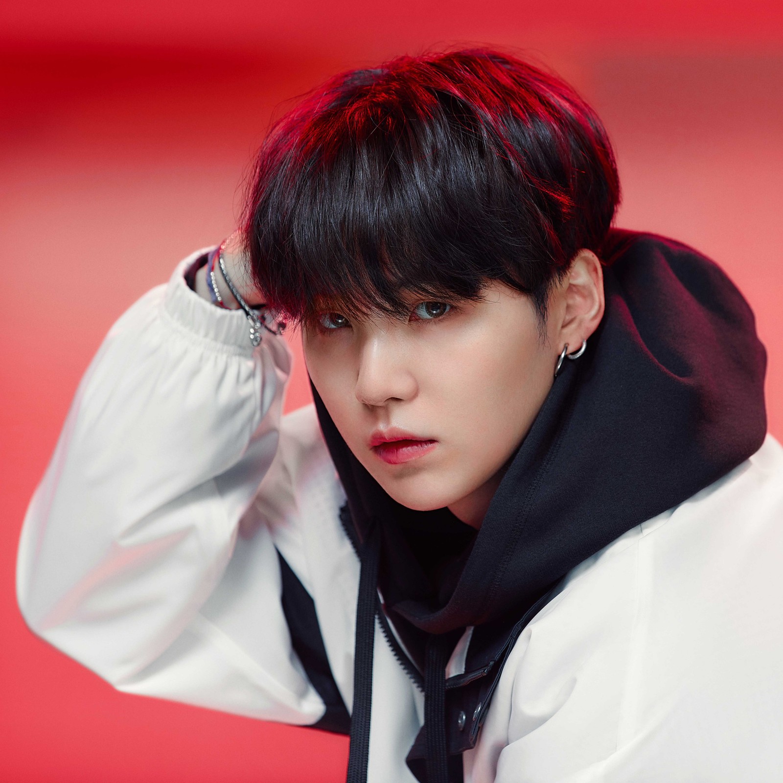 Une image floue d'un homme en cravate et veste blanche (bts, suga)