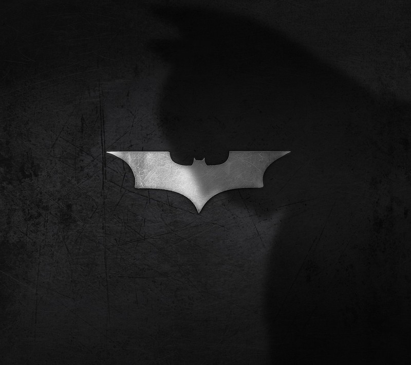 Logo de batman en un fondo oscuro con la sombra de una persona (atjta, haj)