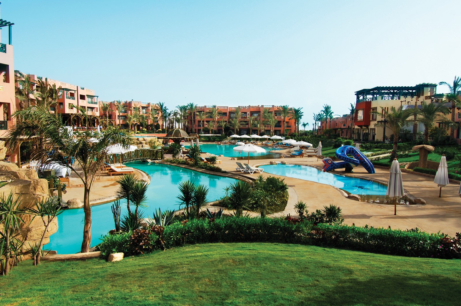 Vista de uma piscina de resort com um escorregador e um toboágua (estância, piscina, férias, cidade turística, lazer)