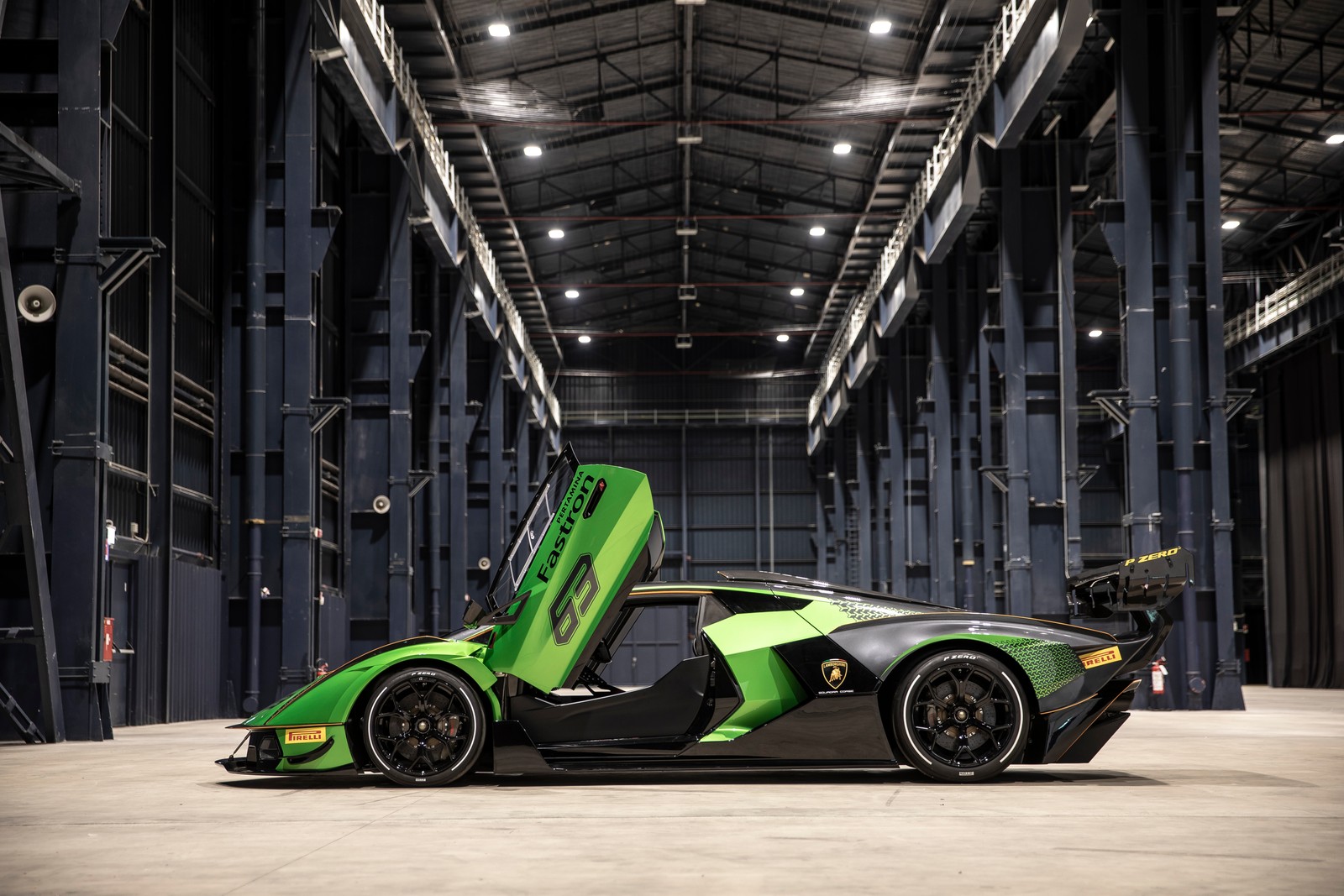 Un coche deportivo verde y negro estacionado en un gran almacén (lamborghini essenza scv12, coche de alto rendimiento, hipercoches, 2021, 5k)