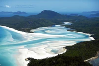 Deslumbrante vista aérea da Praia Whitehaven nas Ilhas Whitsunday, exibindo areias brancas pristinas, águas turquesa e paisagens costeiras exuberantes.