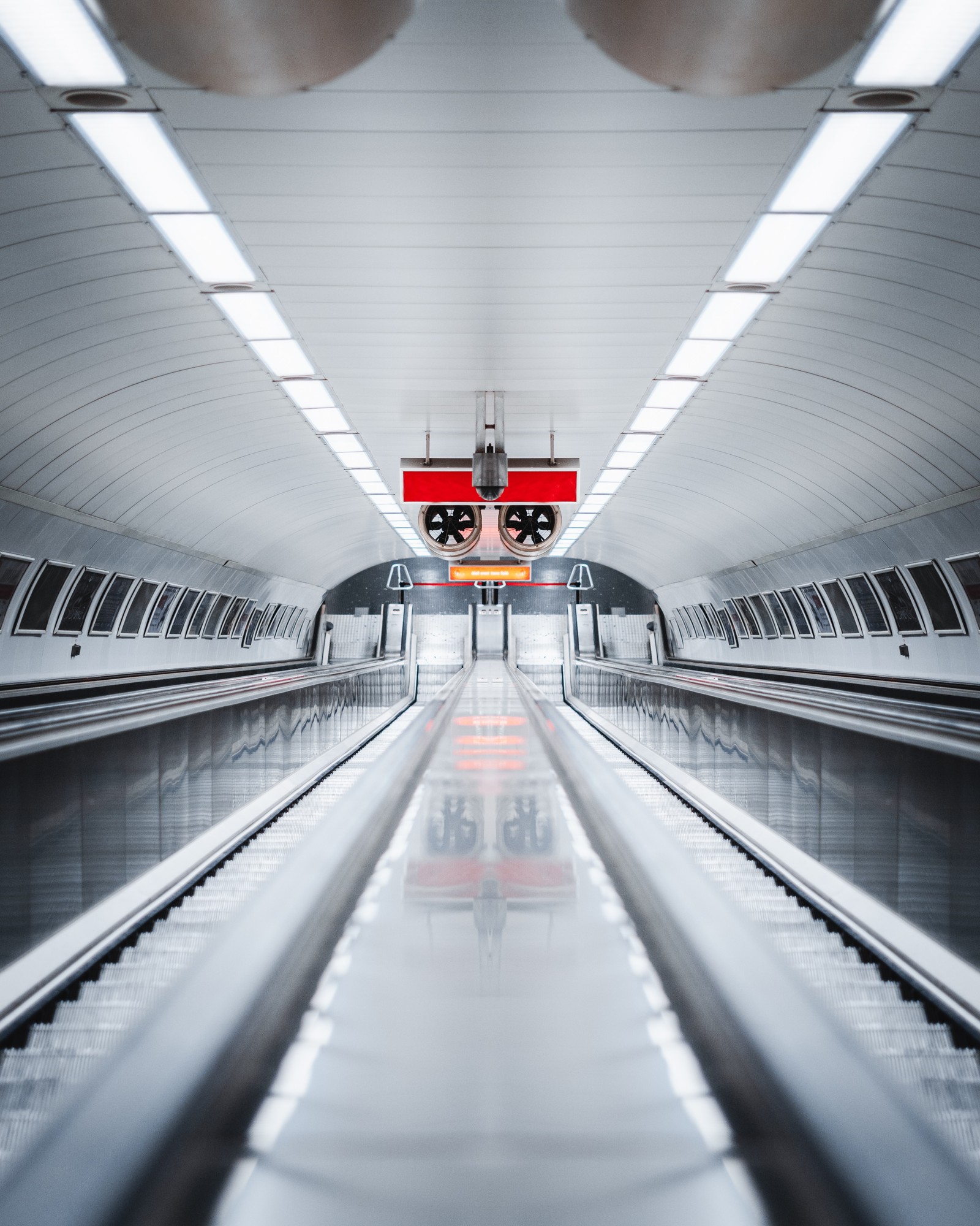 Hay un tren que va por las vías en la estación (escalera mecánica, transporte rápido, transporte, área urbana, línea)