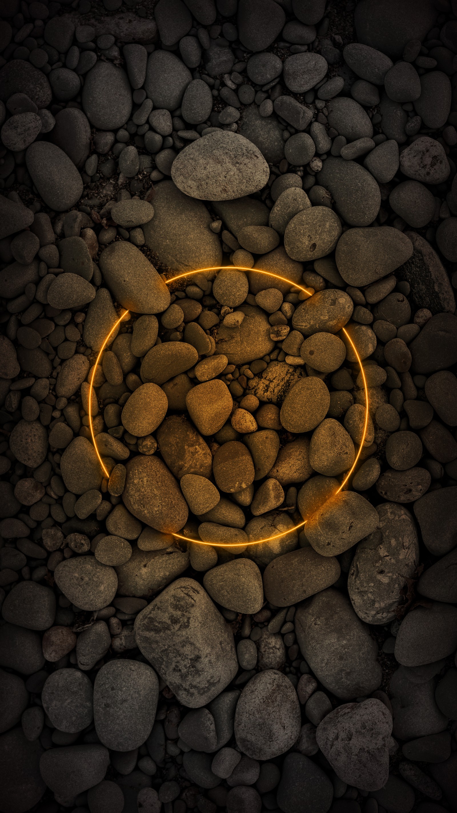 There is a yellow light that is on a rock circle (ios, natural environment, body of water, sunlight, wood)