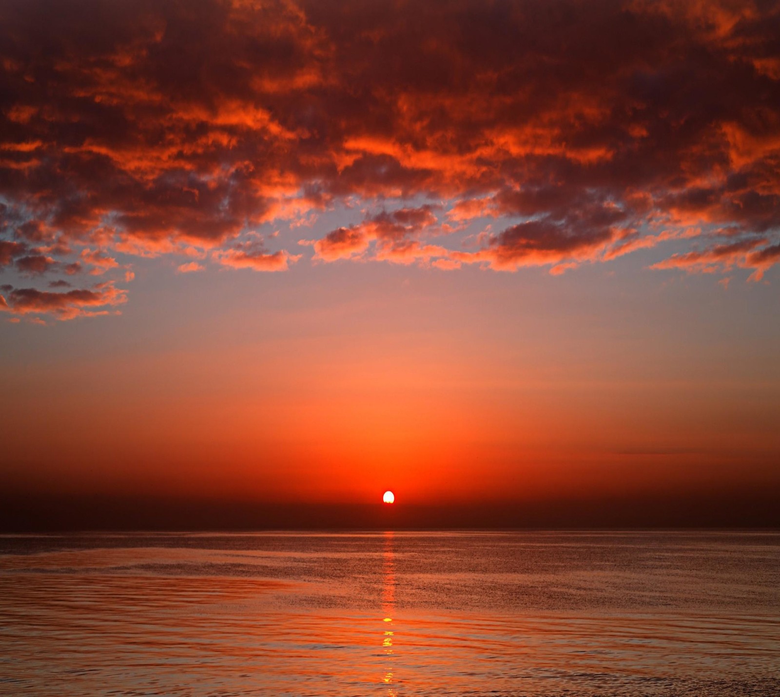 Sunset over the ocean with a boat in the water (landscape, nature, sunset)