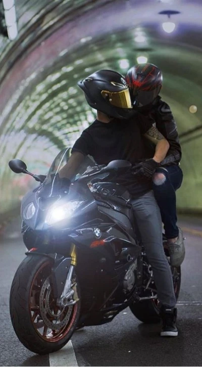 Couple roulant sur une moto BMW Hornet dans un tunnel