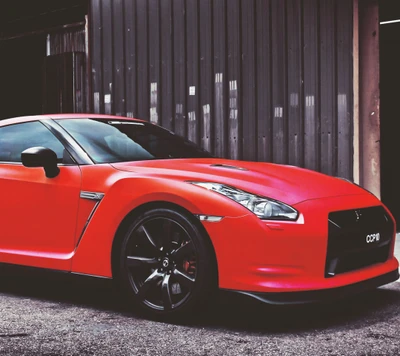 Nissan GTR en rouge frappant contre un arrière-plan rustique.