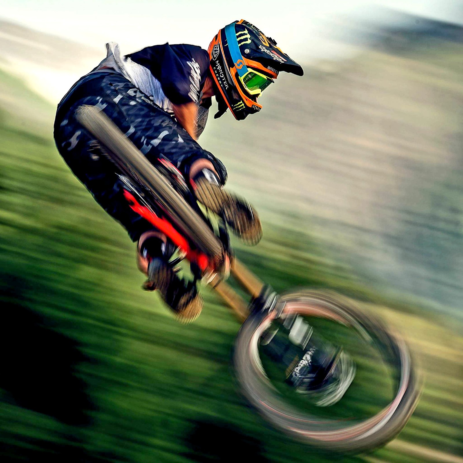 Arafed man riding a bike in the air with a blurry background (bike, downhill, mountain)