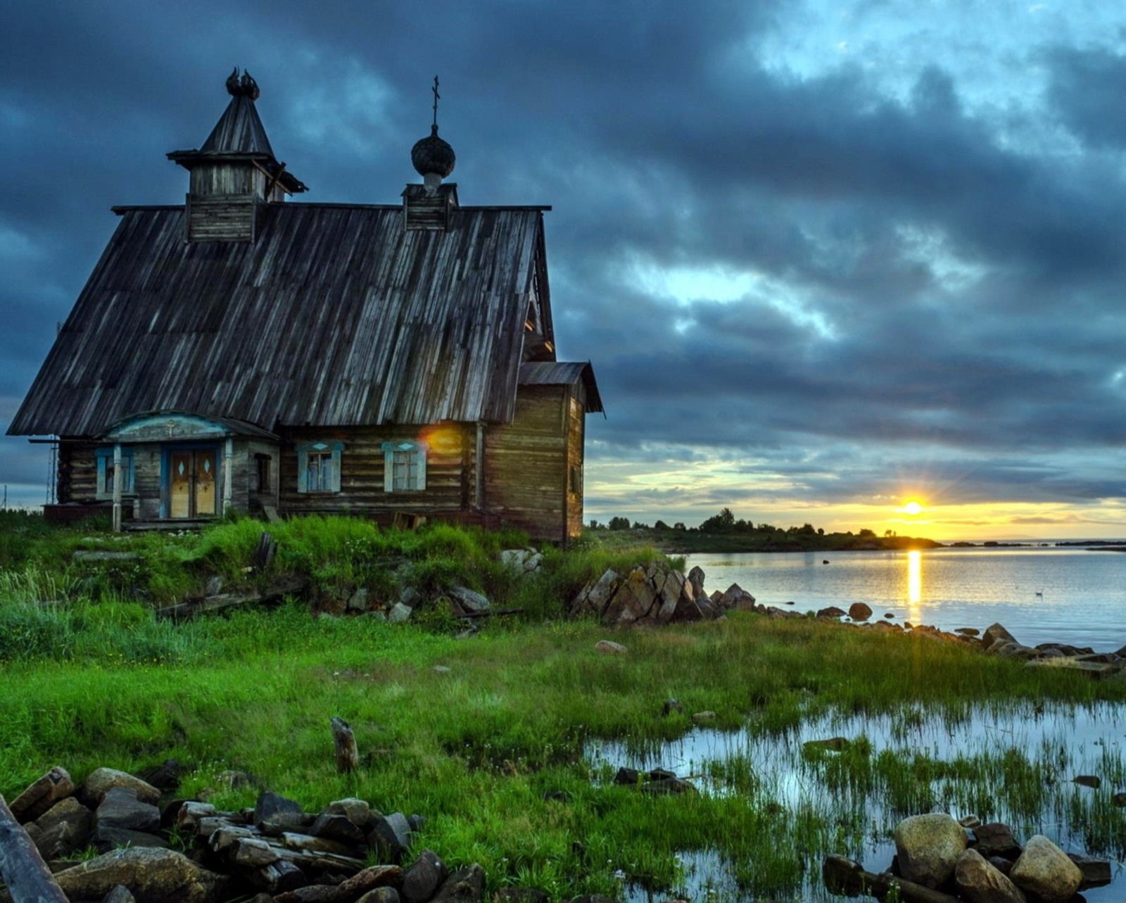 Arafed wooden house sitting on the shore of a lake (christian, lake, landscape, nature, river)