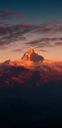 Pic majestueux du mont Everest baigné dans la lueur orange du crépuscule.