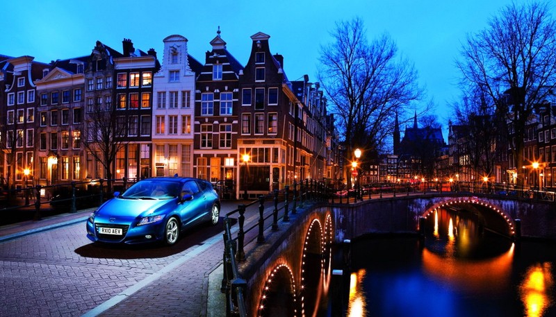 A close up of a car parked on a bridge near a canal (honda motor company, car, honda, landmark, night)