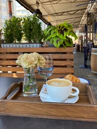 Café y croissant con un toque floral en una mesa acogedora