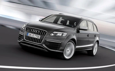 Стильный Audi Q7 в динамическом движении, демонстрирующий современный автомобильный дизайн и спортивную привлекательность.