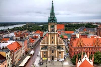 Historische Stadtansicht mit einem mittelalterlichen Turm und einer Spitze