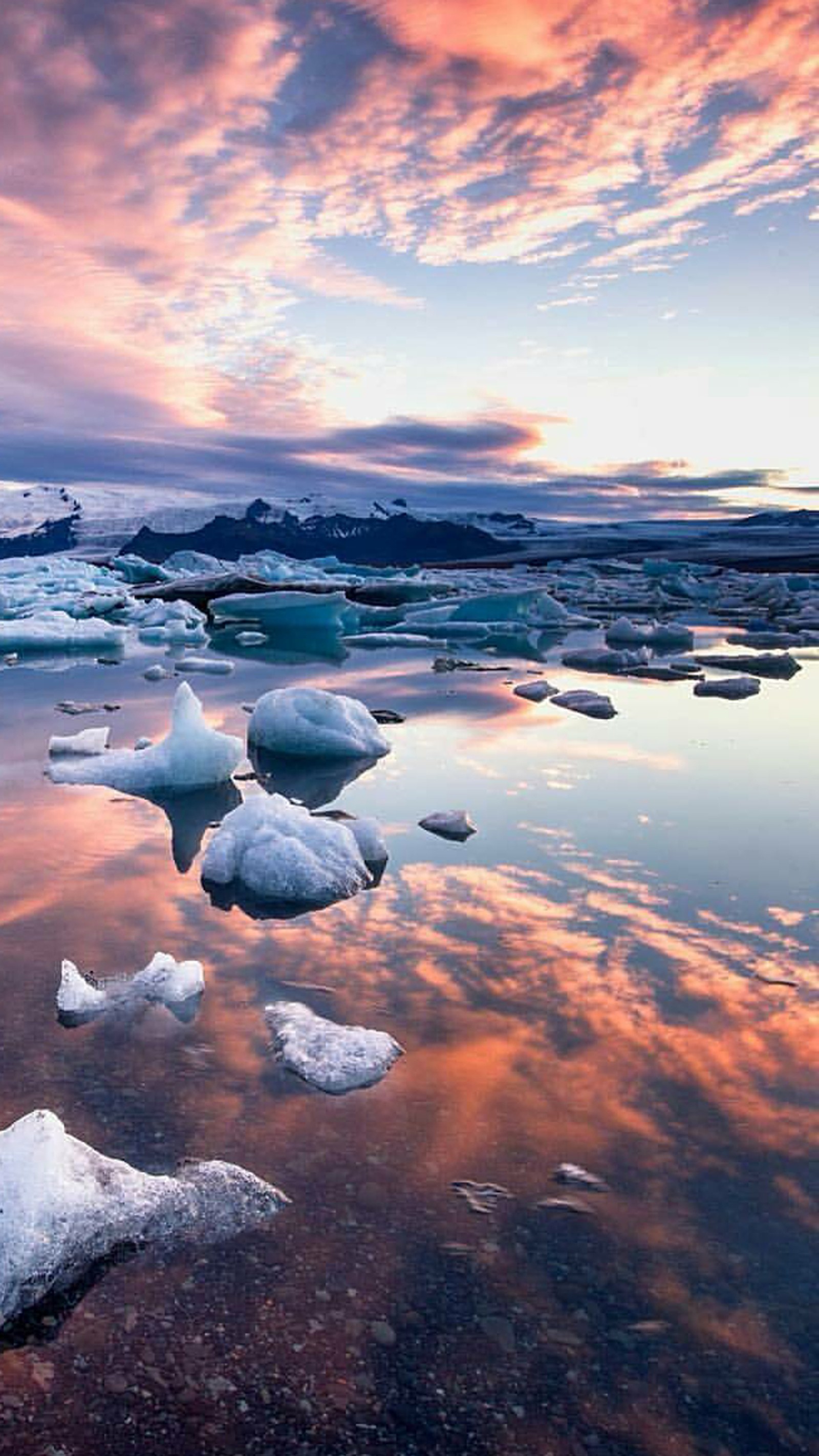 Des icebergs arabes flottent dans un lac avec un coucher de soleil en arrière-plan (plage, glace, nature, coucher de soleil)