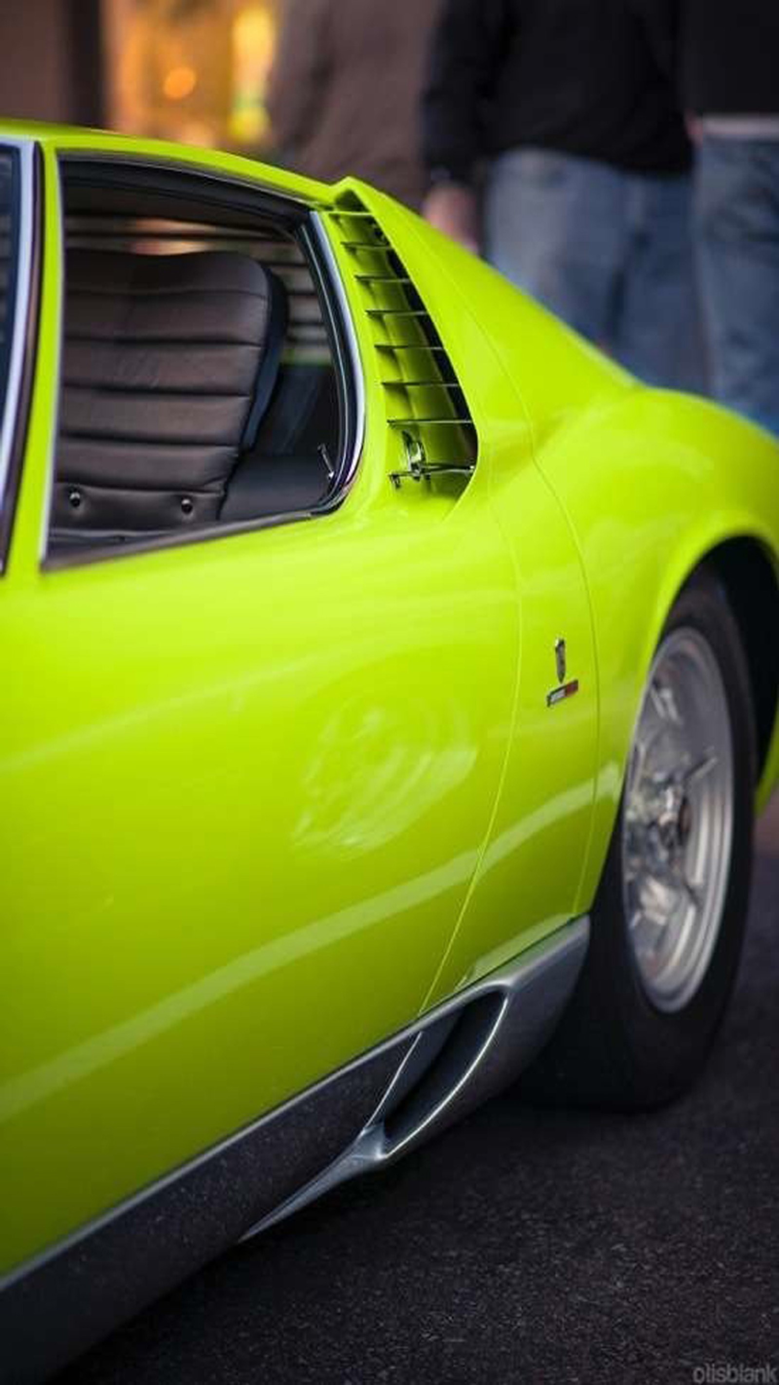 A close up of a yellow car parked on a street (car, muscle, mustang)