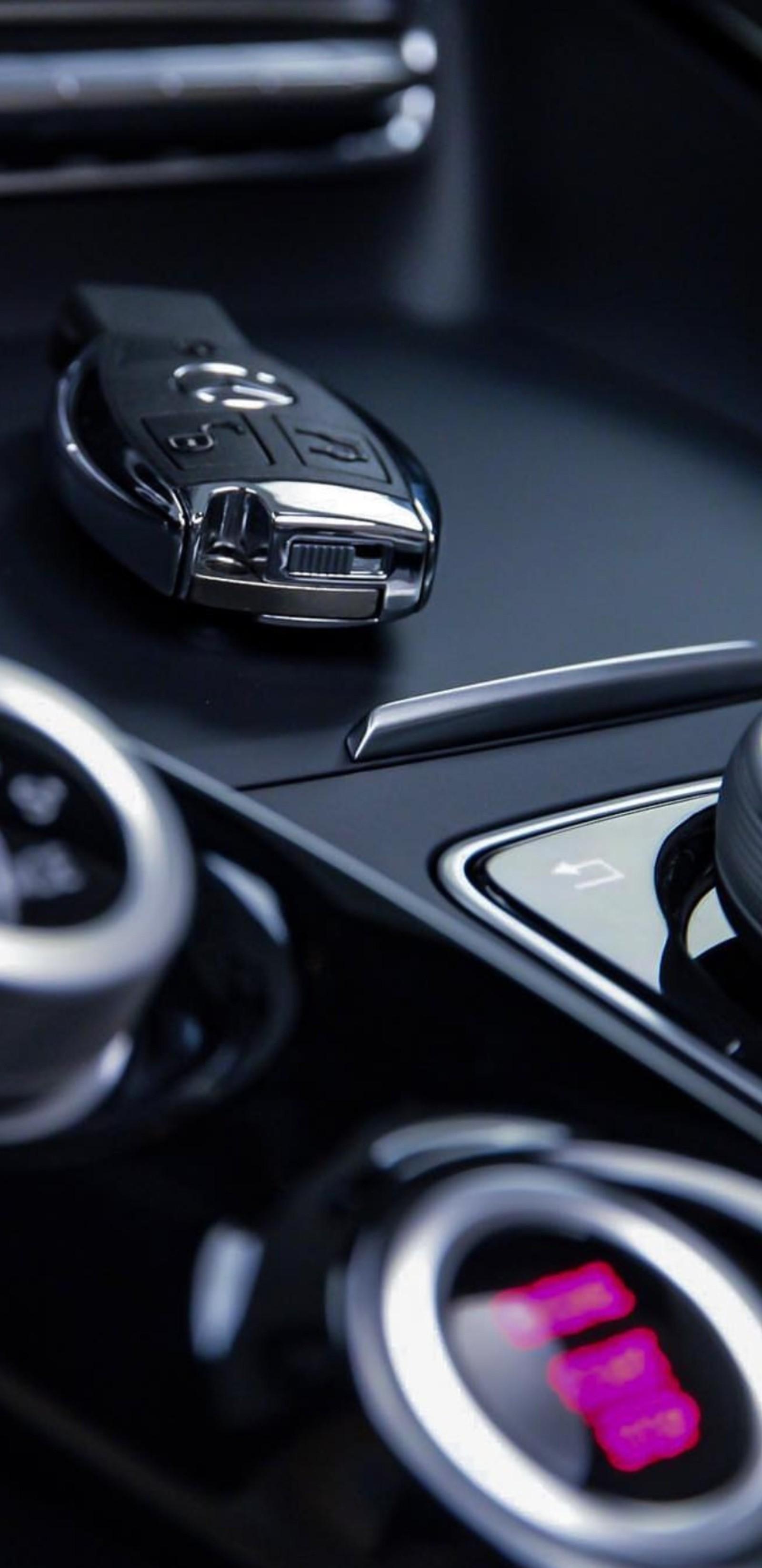 A close up of a car dashboard with a car key and a remote control (amg, benz, black, car, hd)