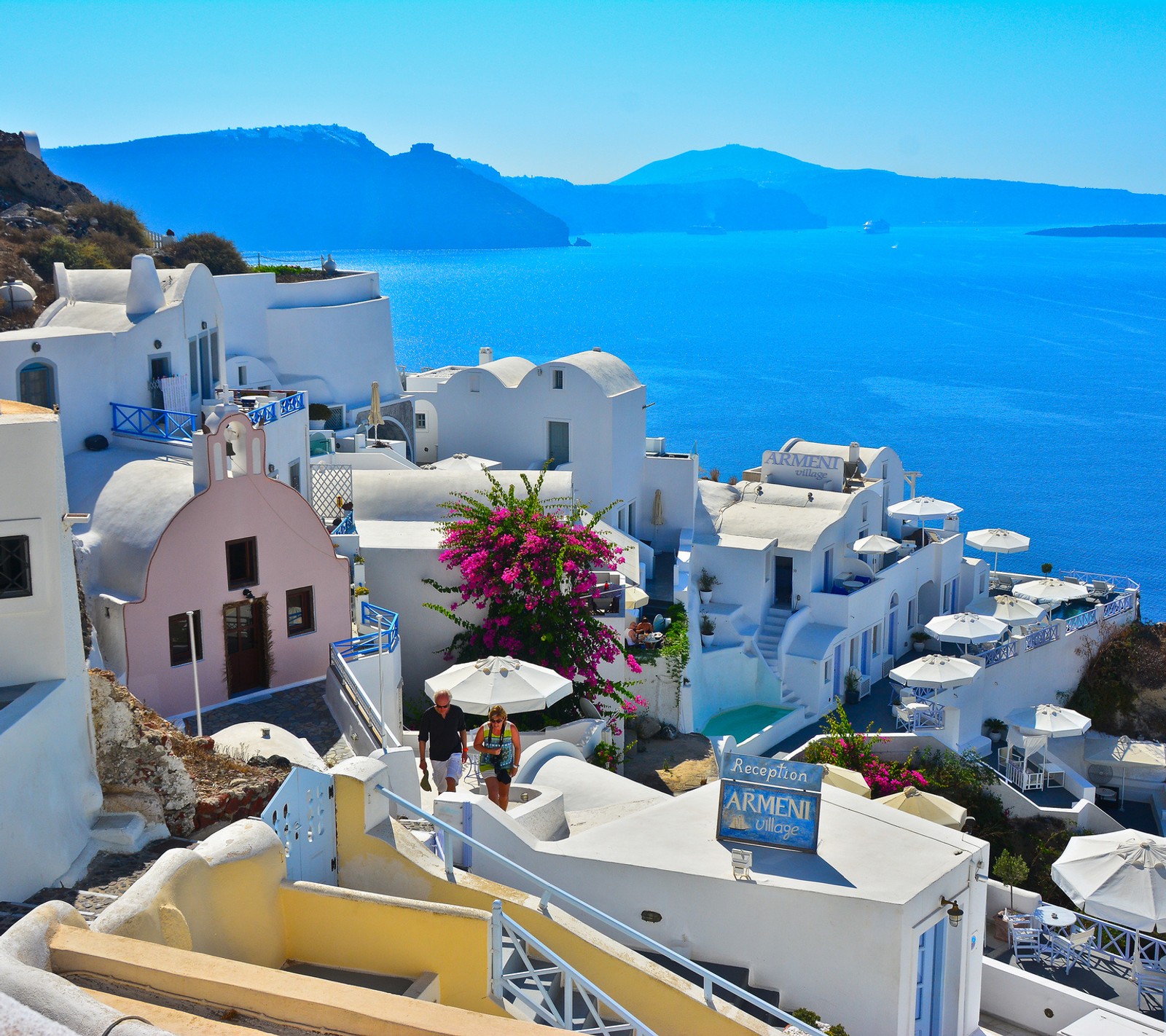 Vista árabe de uma cidade com um mar azul e montanhas ao fundo (grécia, santorini, viagem)