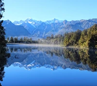 Serene Reflexionen von schneebedeckten Bergen über einem ruhigen See in Neuseeland