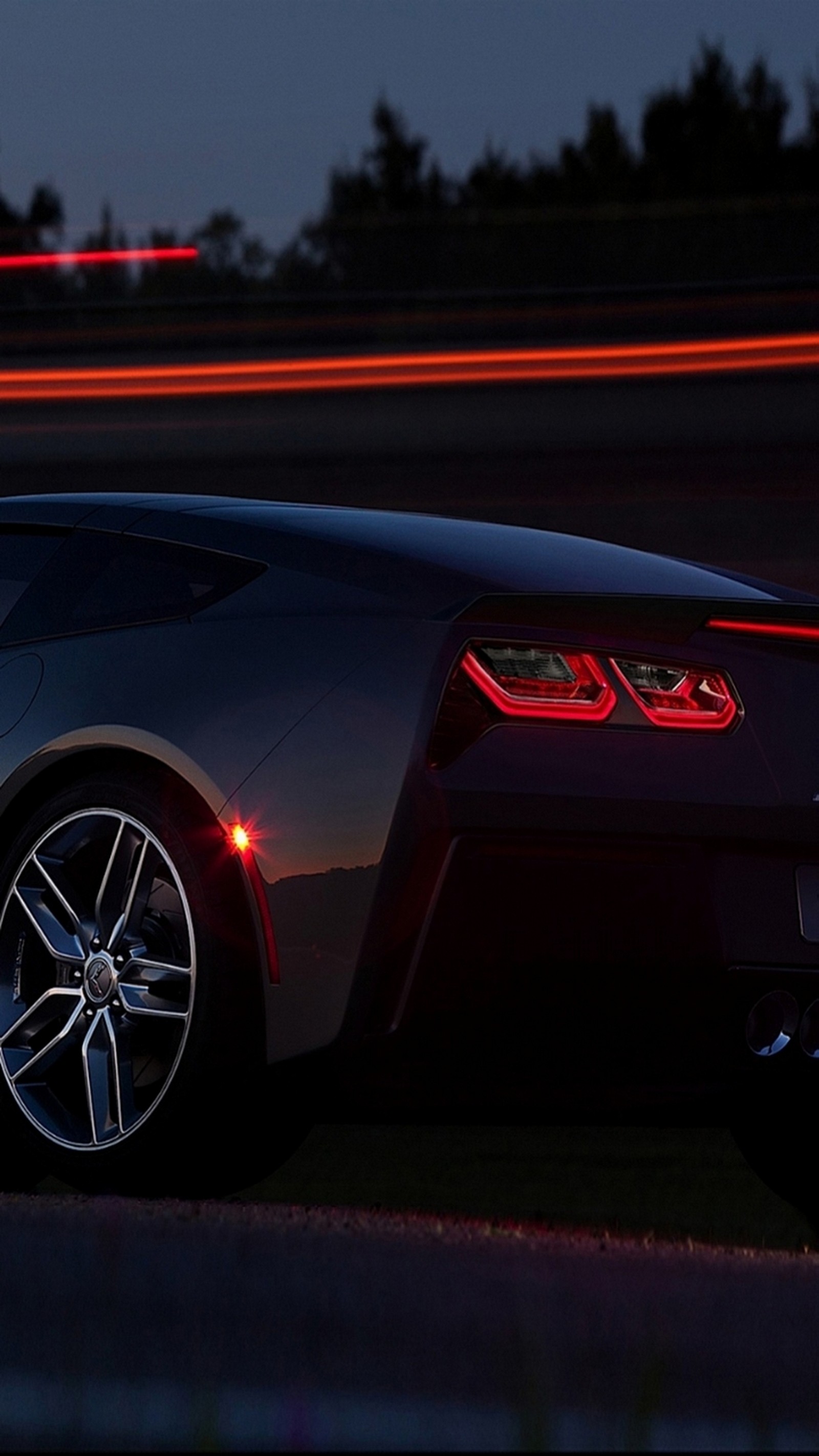 A close up of a sports car driving on a road at night (auto, car, corvette, vehicle)