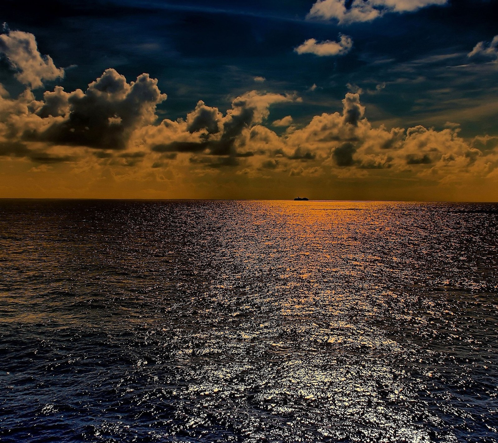 Una imagen de un barco navegando en el océano al atardecer (largo, océano)