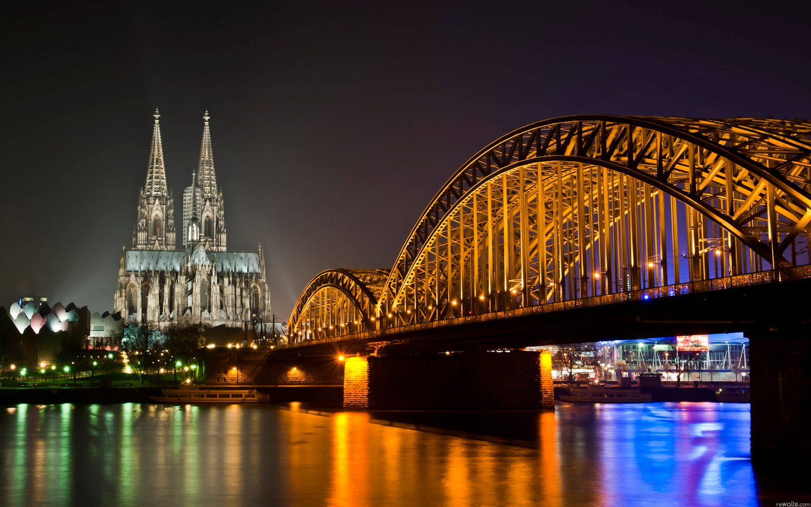 Puente sobre el agua con una catedral de fondo (puente, hito, noche, reflexión, ciudad)