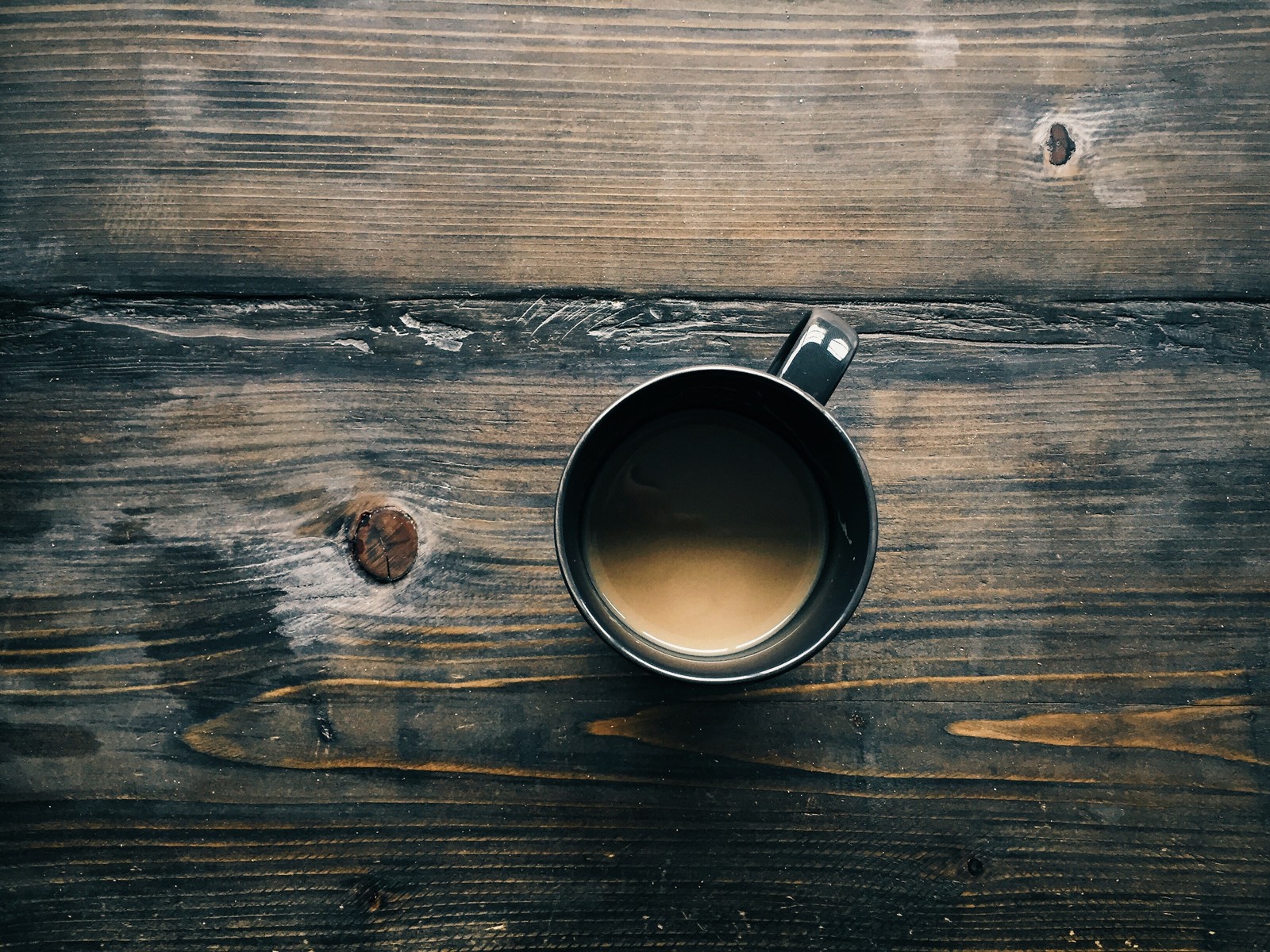 Un gros plan d'une tasse de café sur une table en bois (café, table, tasse à café, tasse, bois)