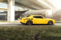 Coche Muscle Dodge Hellcat Amarillo debajo de un paso elevado