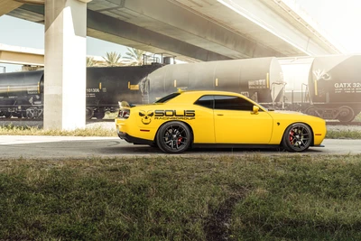 Carro Muscle Dodge Hellcat Amarelo debaixo de um viaduto