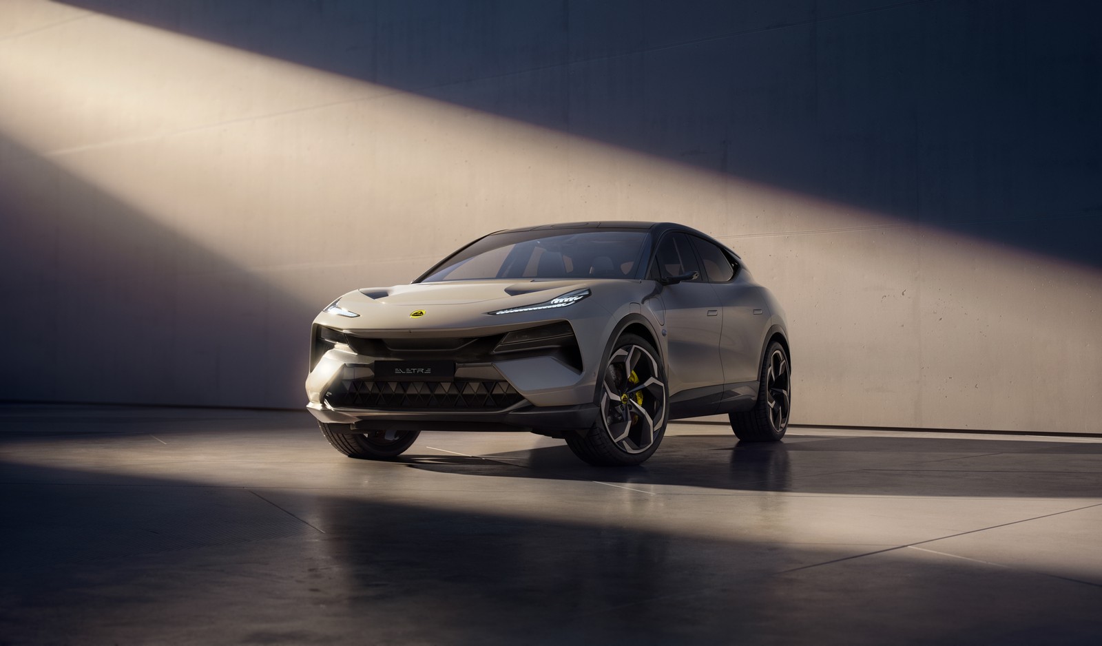 Le nouveau suv est présenté sous les projecteurs sur un sol en béton (lotus eletre, suv électrique, suv hyper, hyper suv, hypercars)