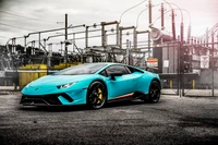 Lamborghini Huracán vibrante em azul elétrico estacionado contra um fundo industrial.