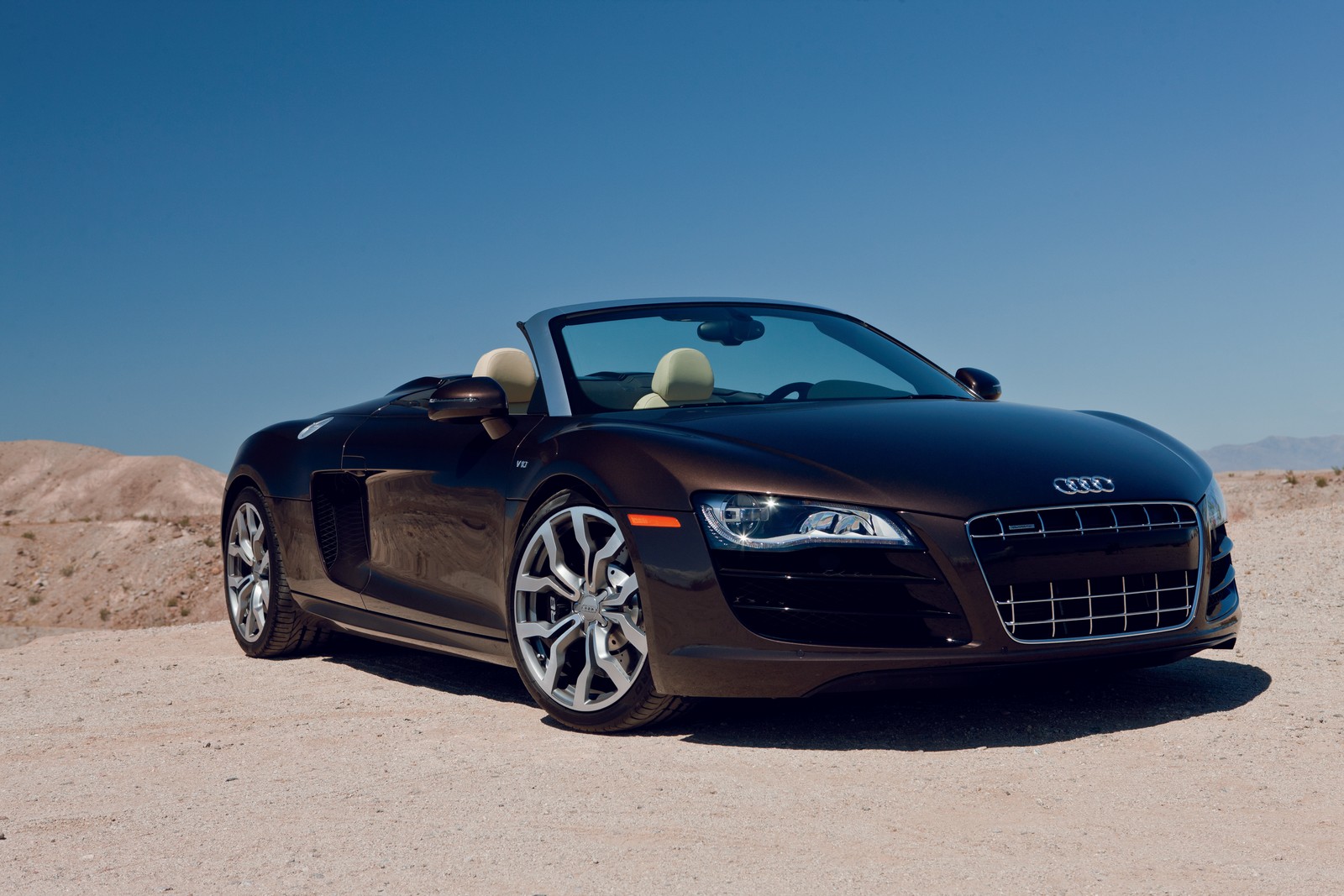 A black audi roadster parked in the desert with a blue sky (sports car, audi, car, audi r8, audi a8)