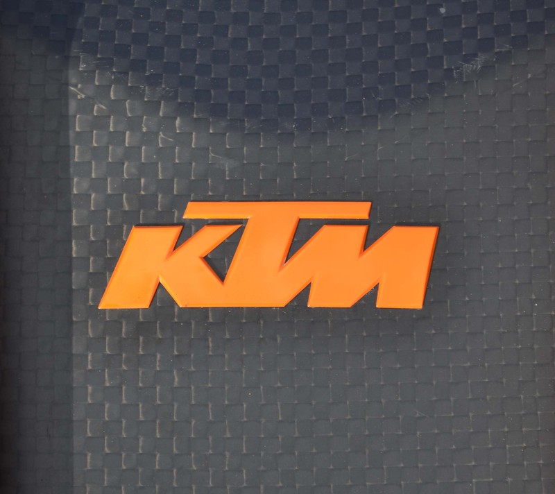 Крупный план логотипа ktm на черном и оранжевом чемодане (ktm, логотип)