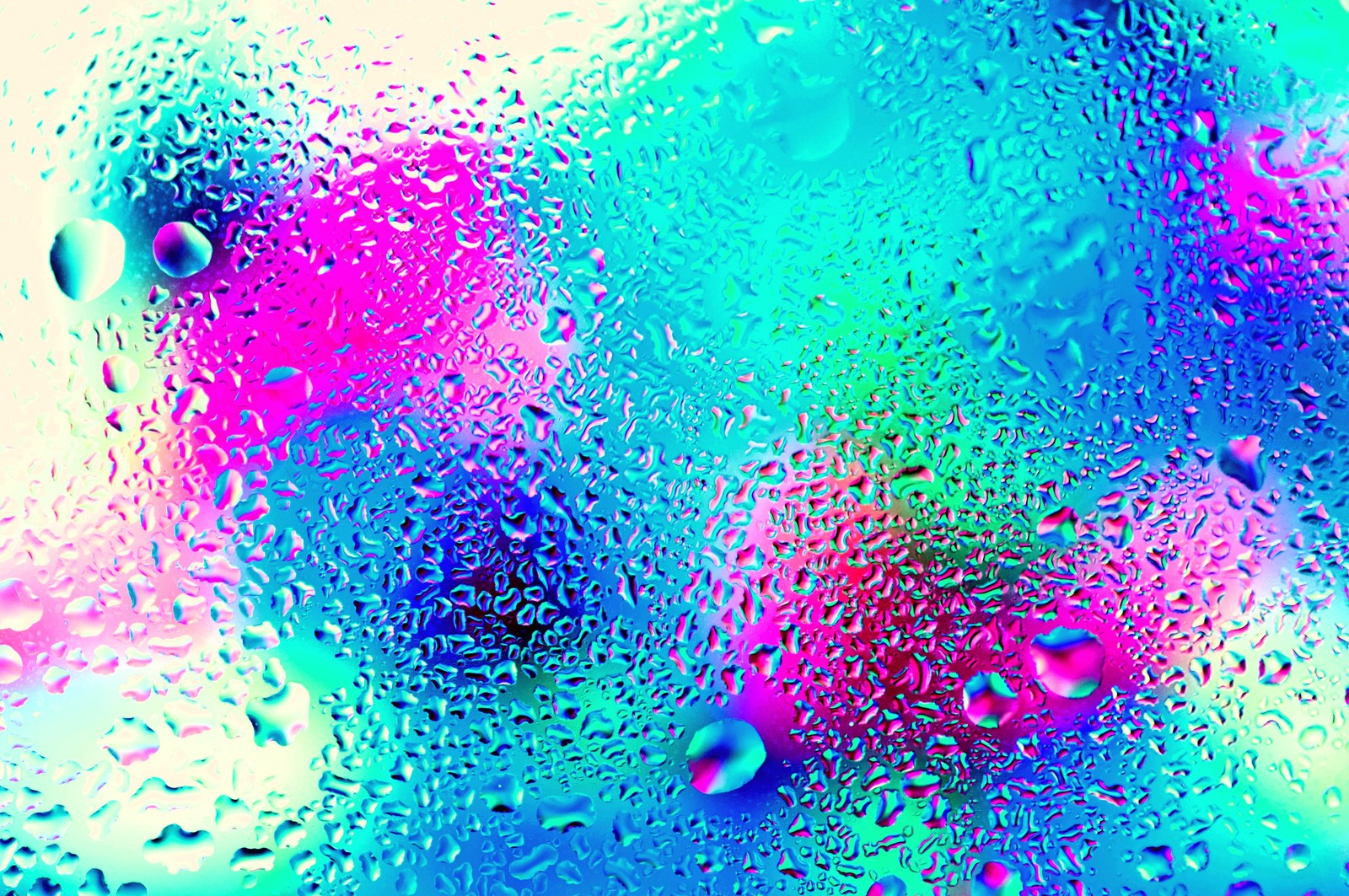 A close up of a colorful liquid filled glass with water droplets (blur neon, blurry window)