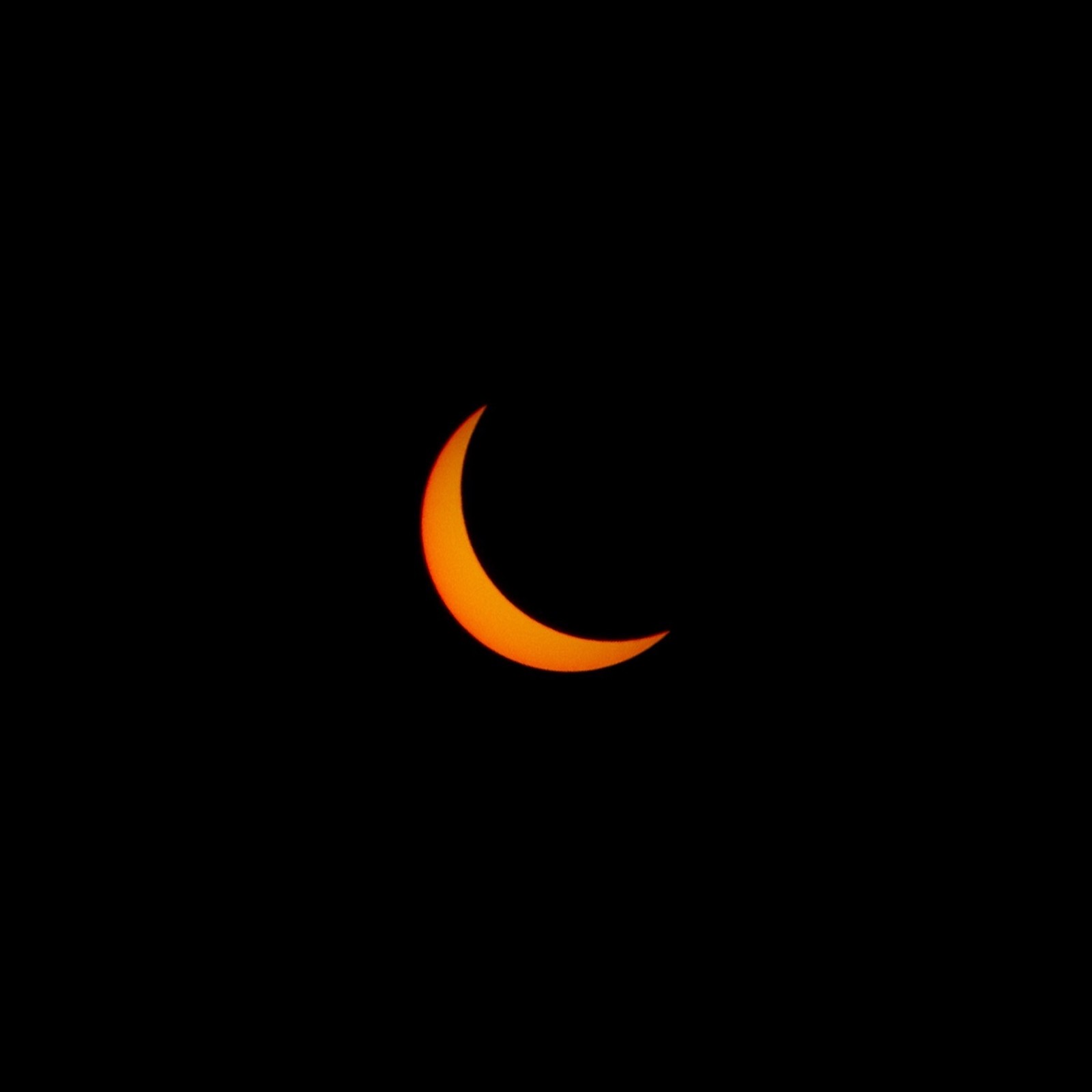 Un gros plan d'un croissant dans le ciel sombre avec un fond noir (croissant, noir, orange, événement céleste, symbole)