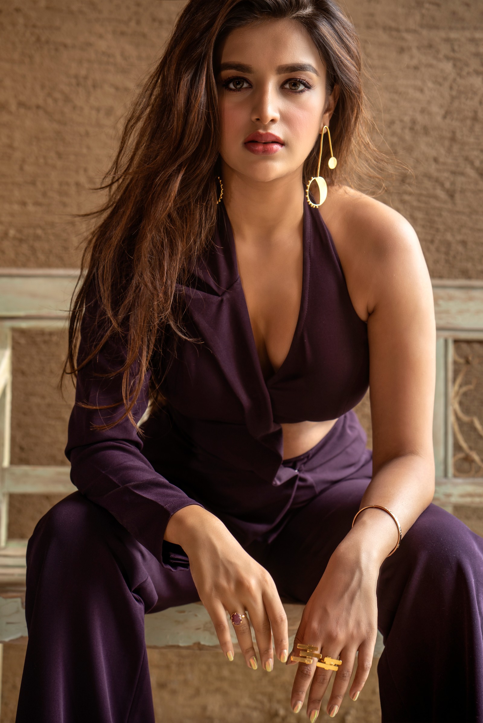 Une femme arabe en robe violette assise sur un banc (nidhhi agerwal, portrait, actrice indienne, actrice du sud, 5k)