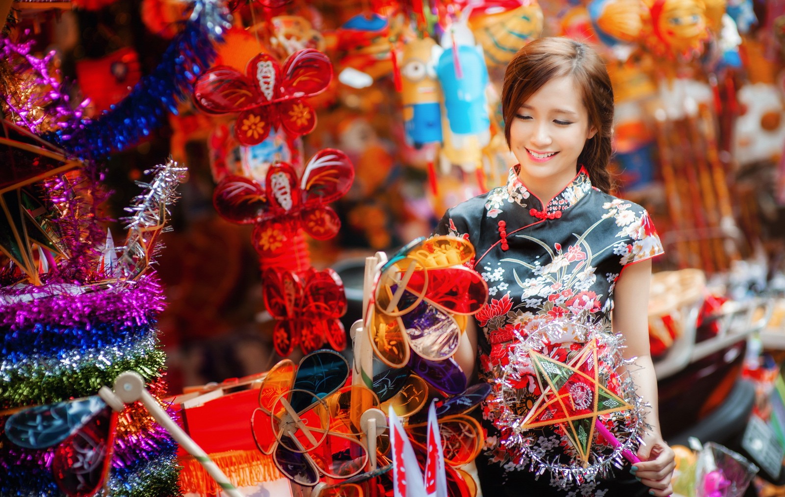 A woman in a dress is standing in front of a display of decorations (mid autumn festival, festival, tradition, event, holiday)