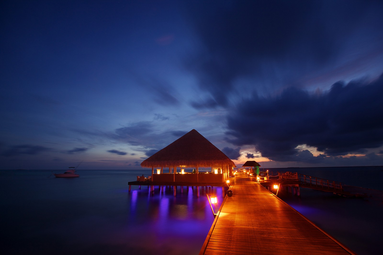 Arabische anlegestelle mit einem restaurant, das nachts beleuchtet ist (strand, nacht, wolke, meer, ozean)