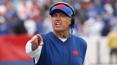 Buffalo Bills Coach passionately motivating players during a competitive NFL game.