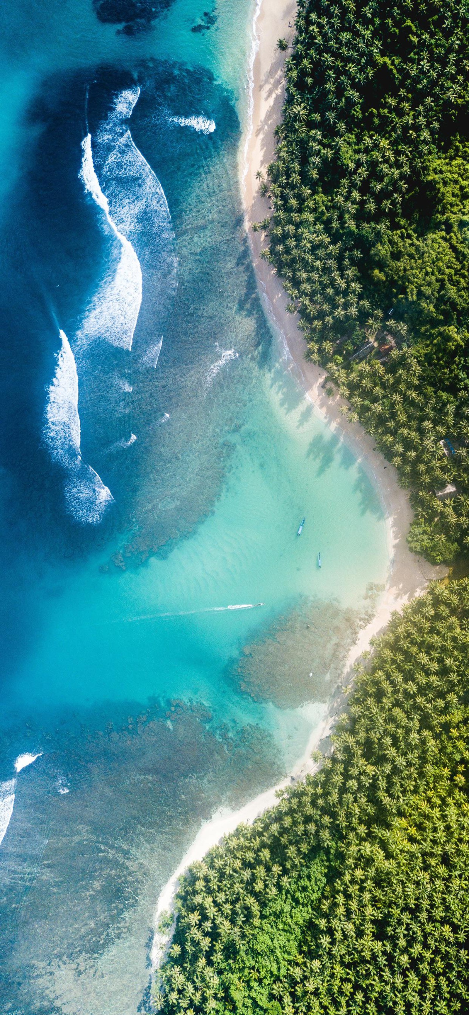 Draufsicht auf einen strand und ein gewässer mit einem boot (äpfel, wasser, wasserressourcen, azurblau, natürliche landschaft)