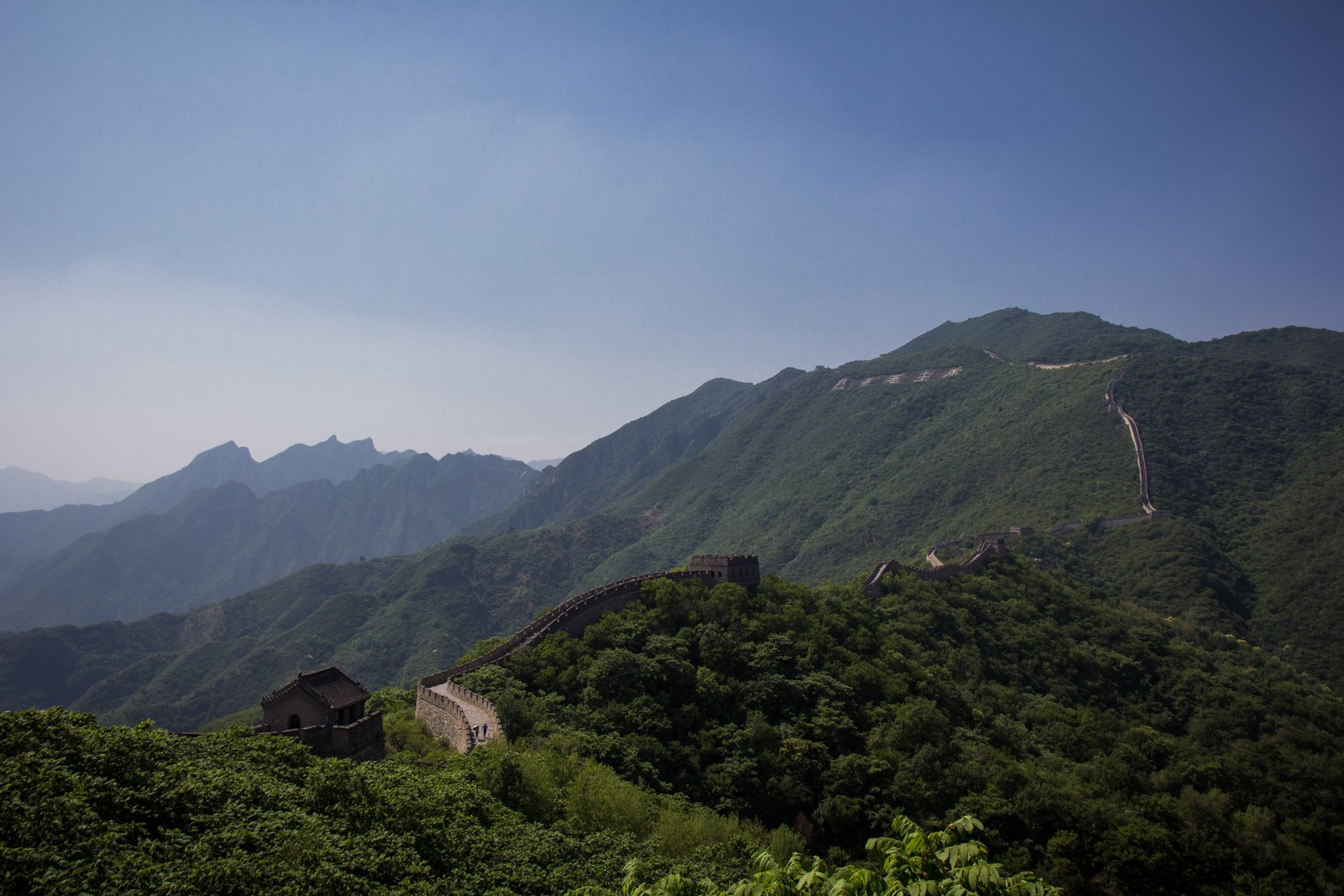 Vista de uma seção da grande parede da china com uma montanha ao fundo (grande muralha da china, formas montanhosas, montanha, estação de montanha, terras altas)