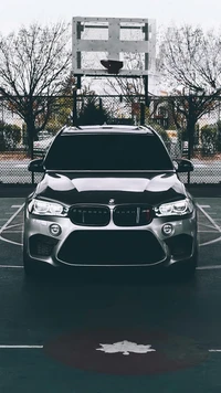 BMW X5 M: SUV prateado de luxo na quadra de basquete