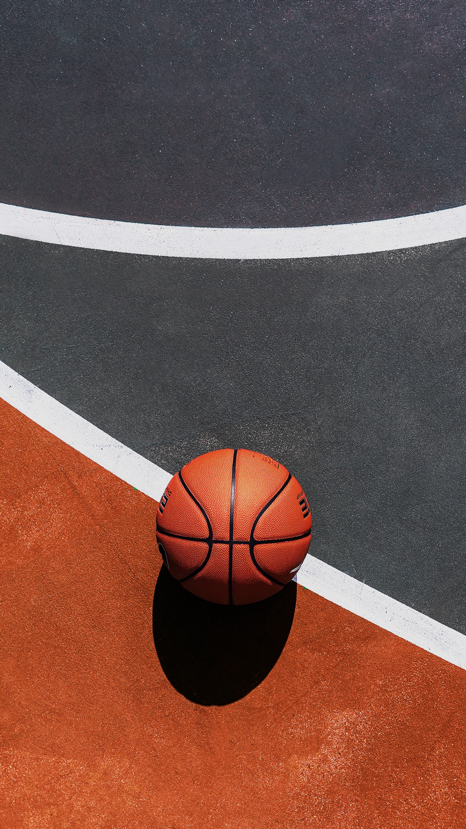 Un balón de baloncesto en una cancha con una línea blanca (baloncesto, juego, fútbol)