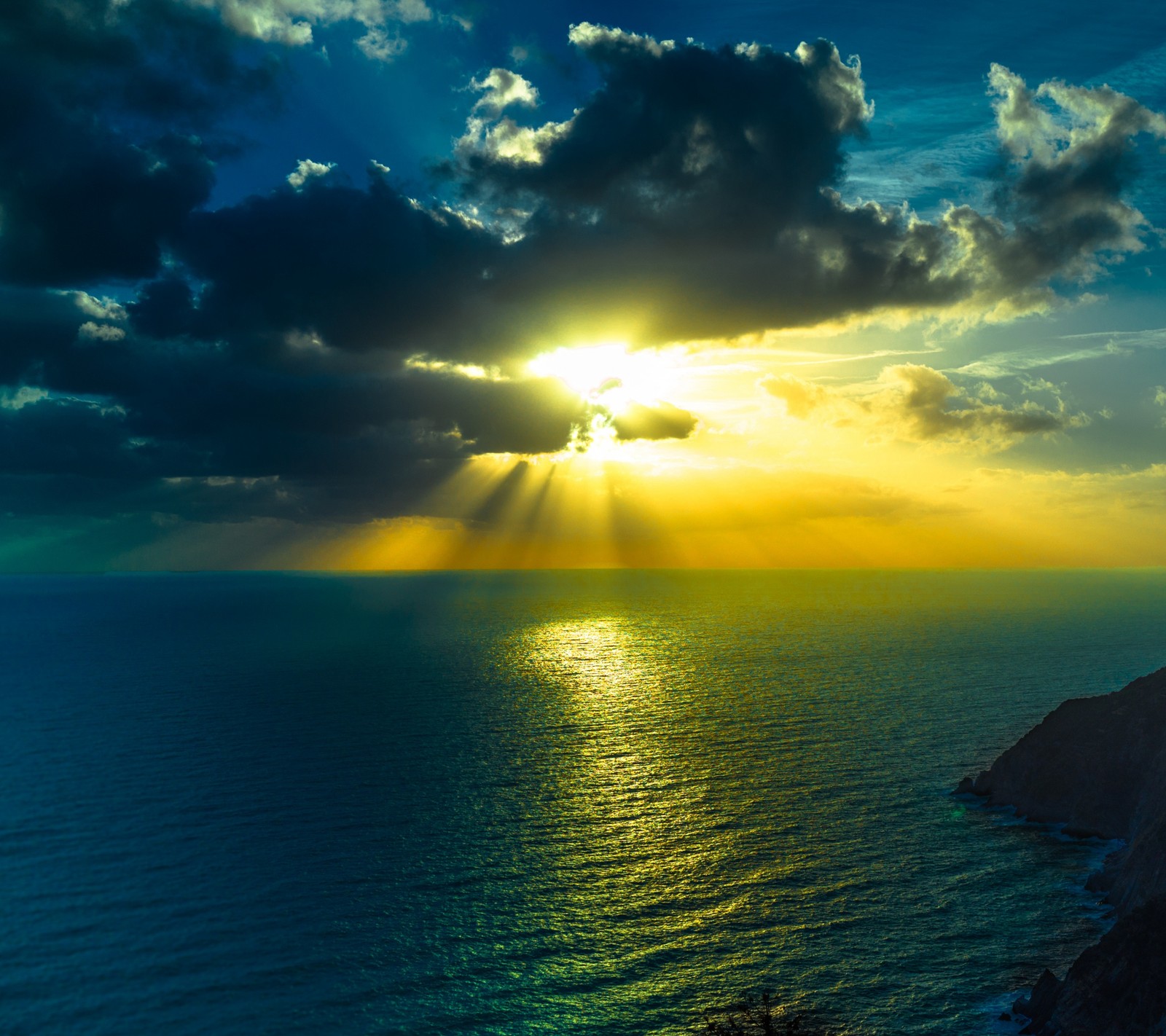 Vue d'un coucher de soleil sur l'océan avec un rayon de soleil (nuages, crépuscule, soir, nature, océan)