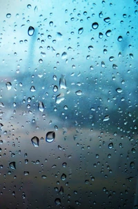 Gotas de lluvia sobre una superficie de vidrio con un fondo de cielo azul