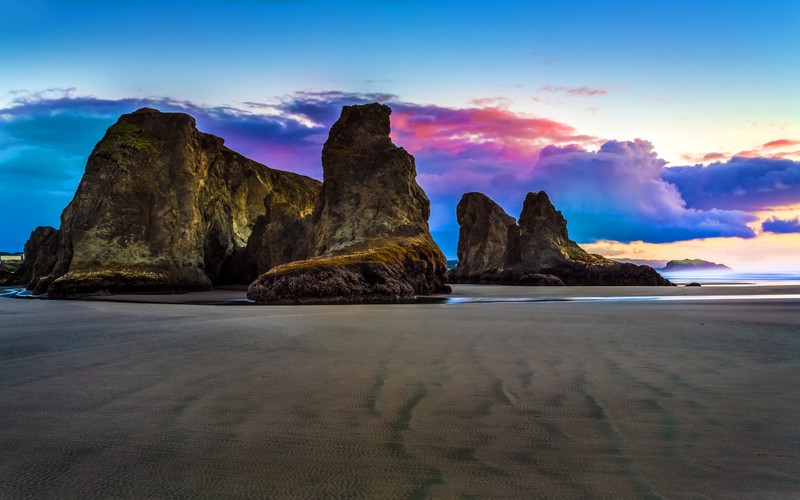 Арафедные скалы на пляже на фоне заката (bandon beach, морские скалы, пляж, скалистый берег, облачное небо)