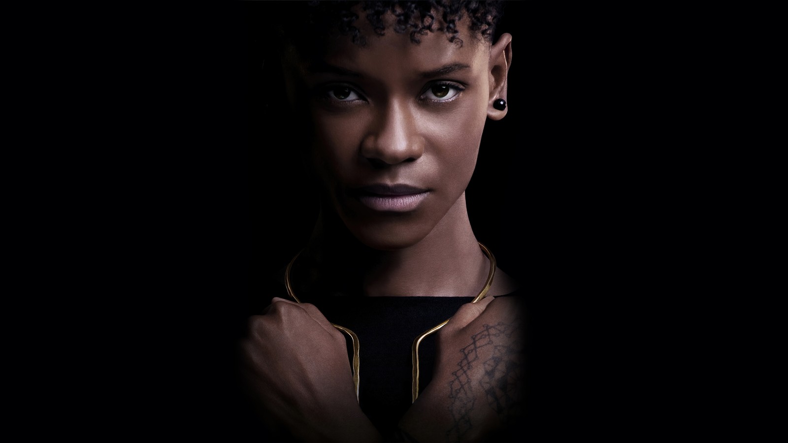 Gros plan d'une femme portant un chemisier noir et un collier en or (shuri, letitia wright, black panther wakanda forever, film, black panther 2)