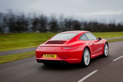 Porsche 911 GT2 in auffälligem Rot, das sein schlankes Design und seine leistungsstarke Performance auf einer malerischen Straße zur Schau stellt.