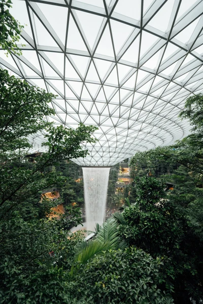 Cascada interior rodeada de exuberante vegetación en un jardín botánico moderno