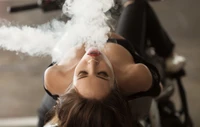 Fille exhalant de la vapeur d'une cigarette électronique